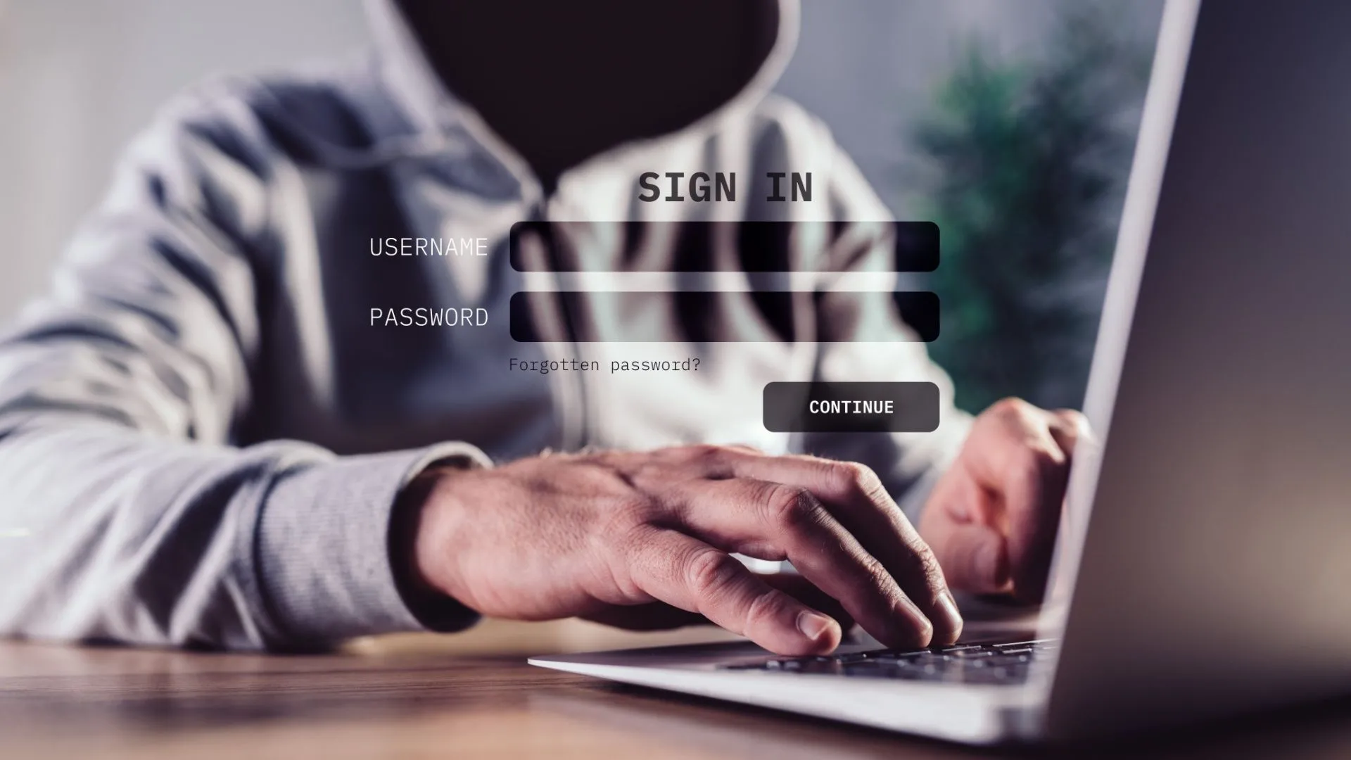 Hình minh họa một kẻ tấn công đội mũ trùm dùng laptop — biểu tượng rủi ro an ninh khi công bố mã nguồn cũ