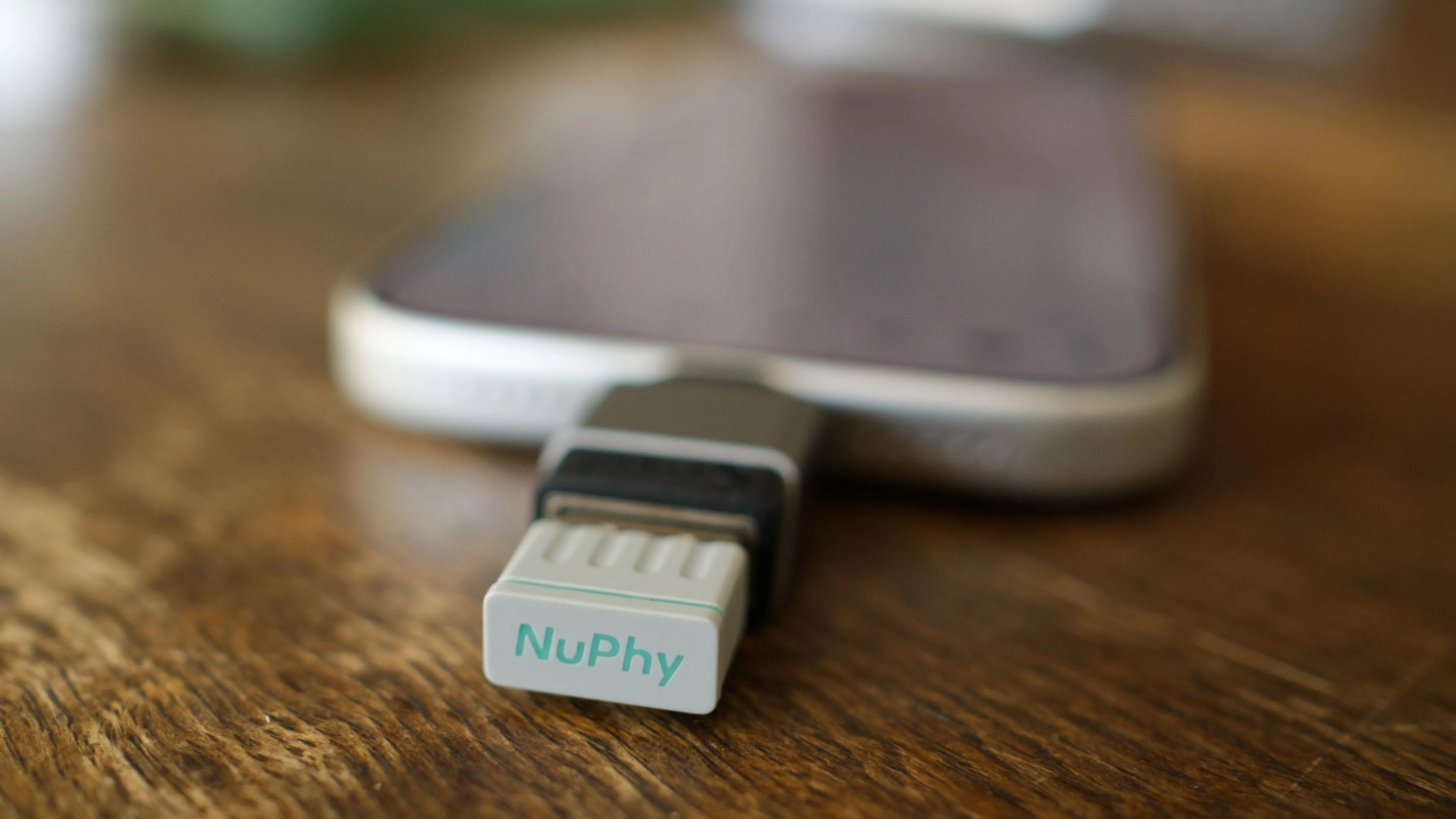 iPhone 17 Pro kèm dongle không dây 2.4GHz của NuPhy, minh họa kết nối bàn phím cơ.