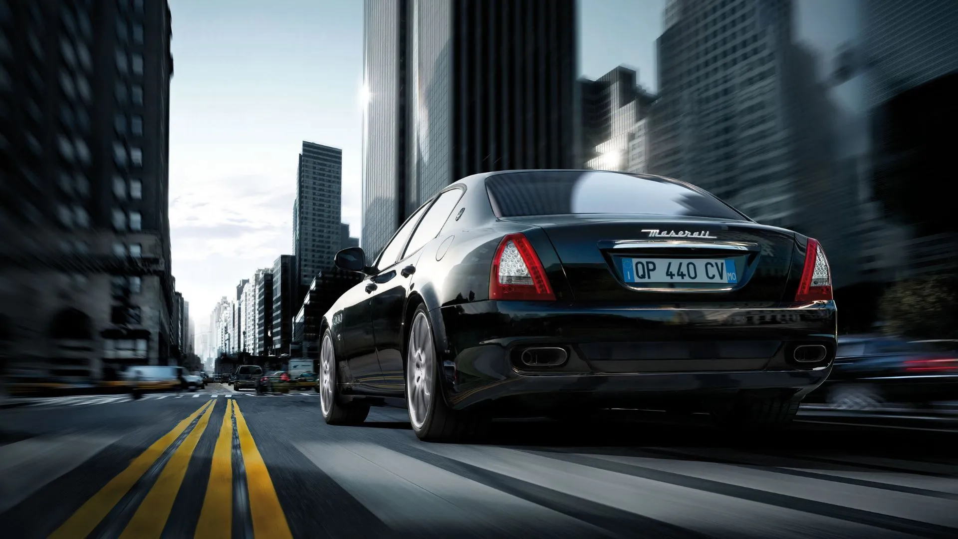 Maserati Quattroporte S đen đang chạy trên đường thành phố, minh họa khả năng vận hành mạnh mẽ.
