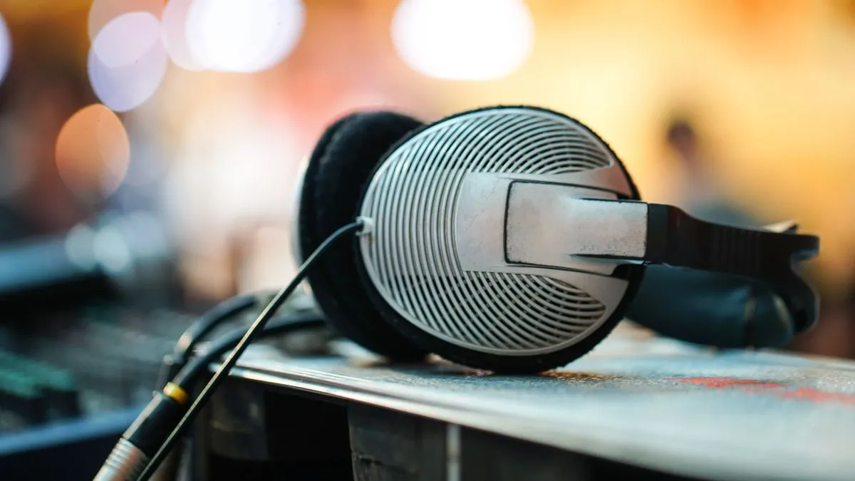 Tai nghe có dây đặt trên bề mặt bàn, cùng thiết bị thiết bị âm thanh trong nền, tượng trưng cho việc cần phần cứng tốt để nghe lossless