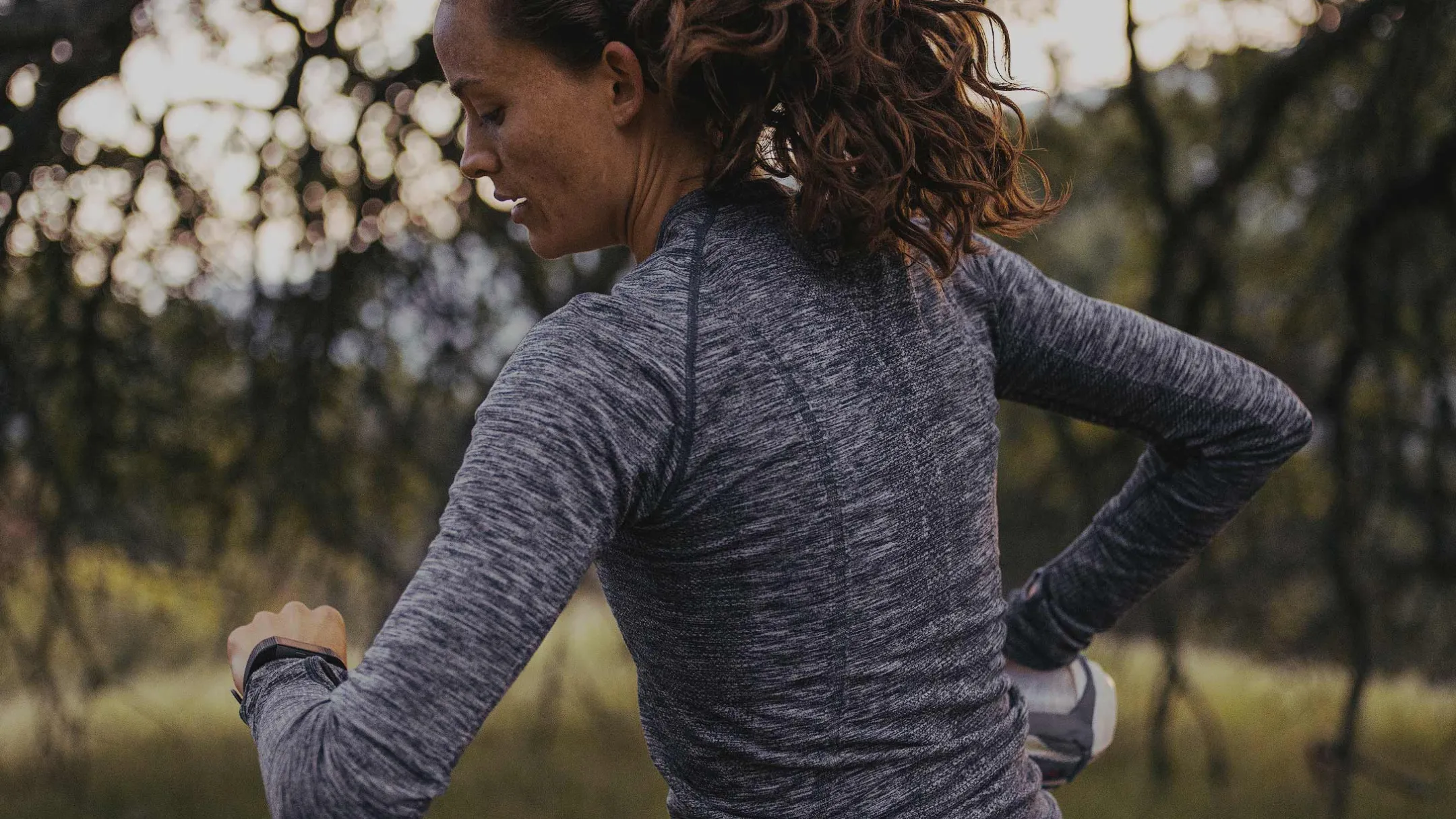 Vận động viên kiểm tra đồng hồ Garmin với ứng dụng Strava trên màn hình, minh họa mối liên hệ dữ liệu giữa hai nền tảng